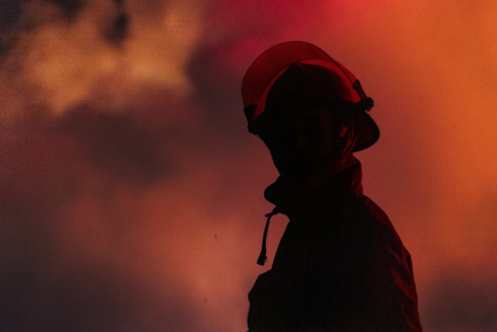 fire man in uniform with fire in background