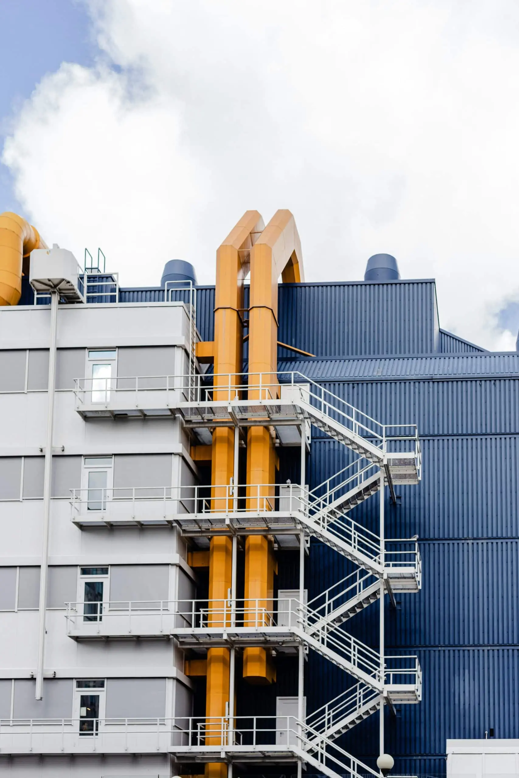 outside of an industrial building. Stairs and yellow piping