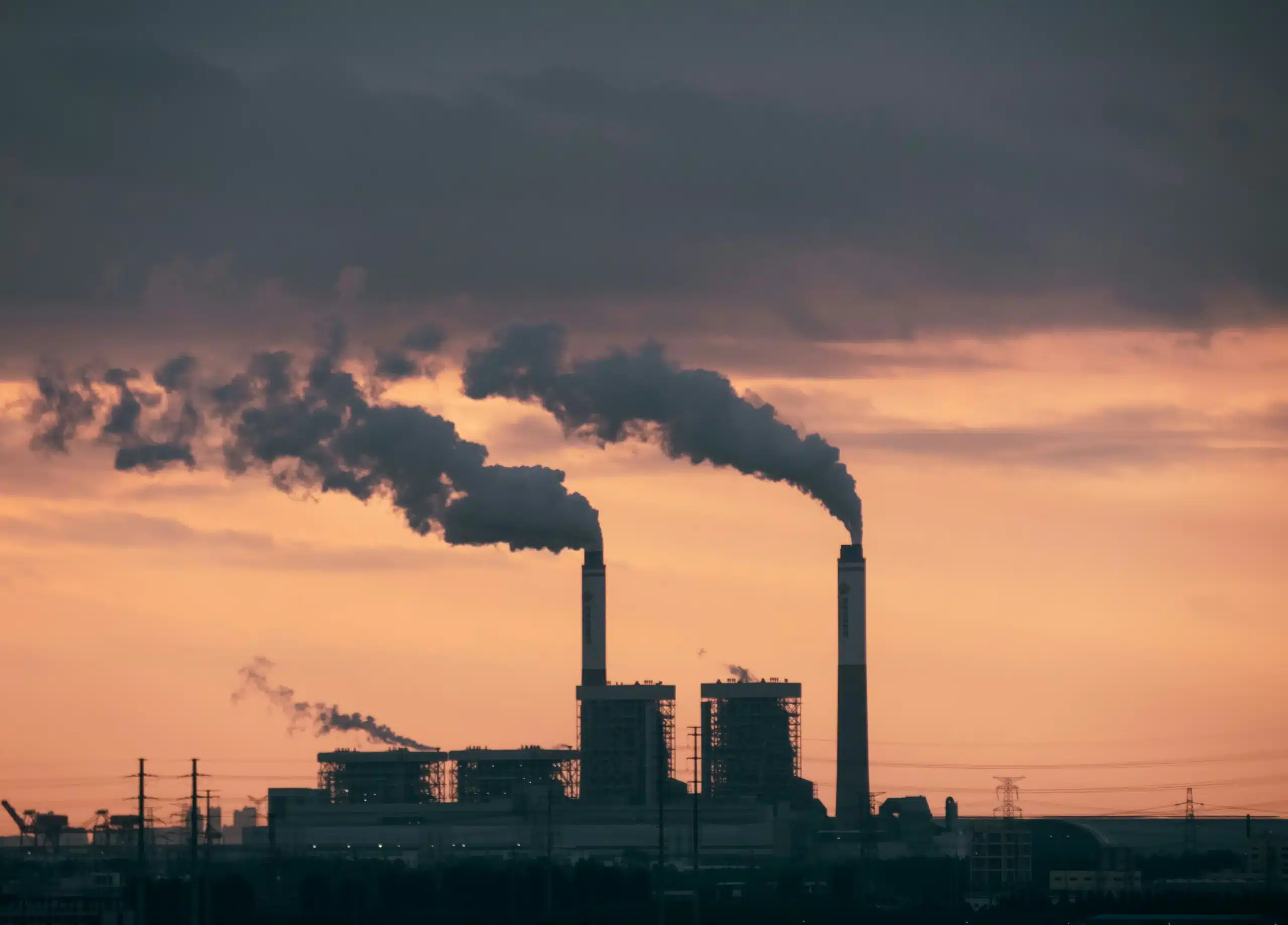 factory with smoke and orange sky and dark clouds