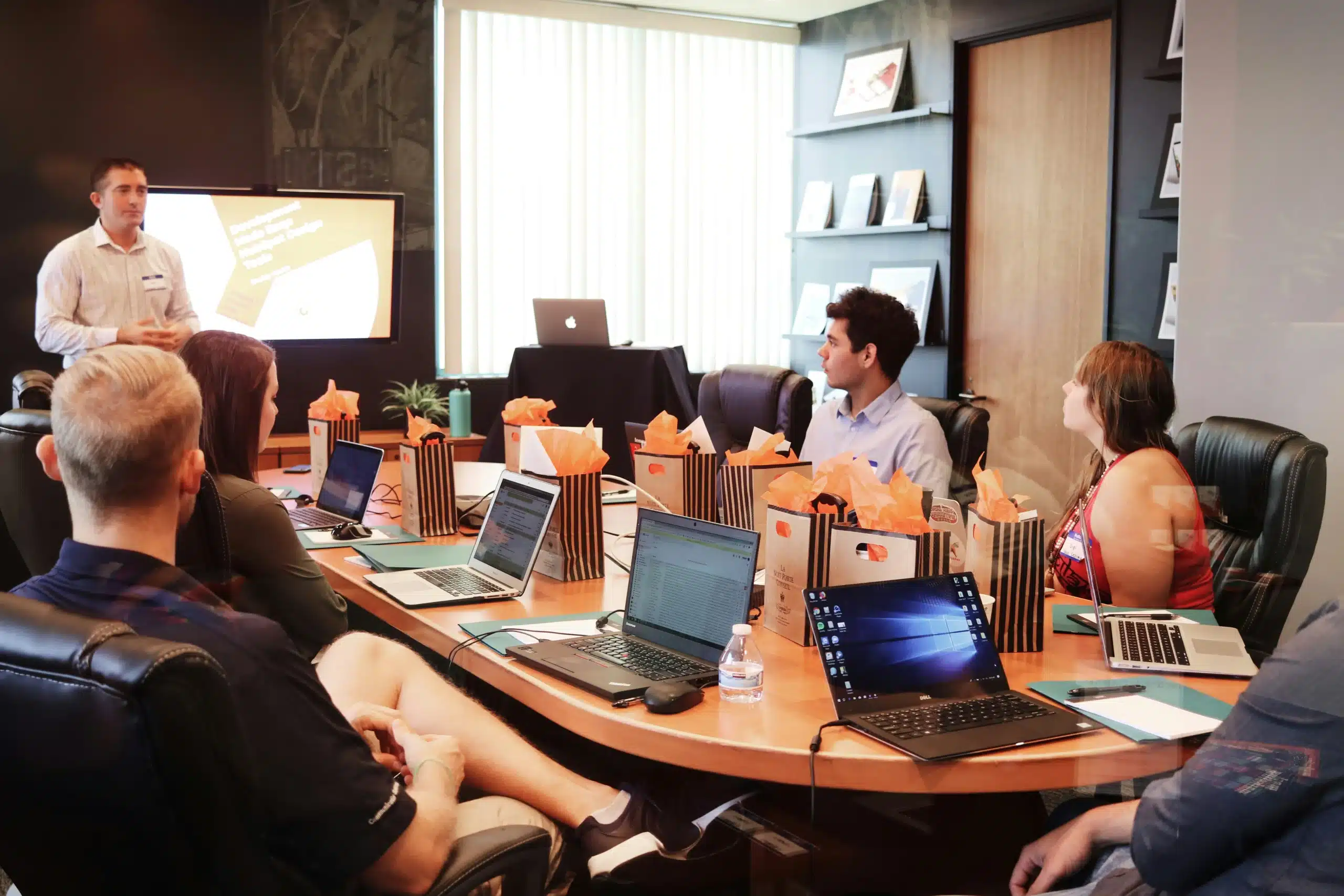 people gathered round table with laptops